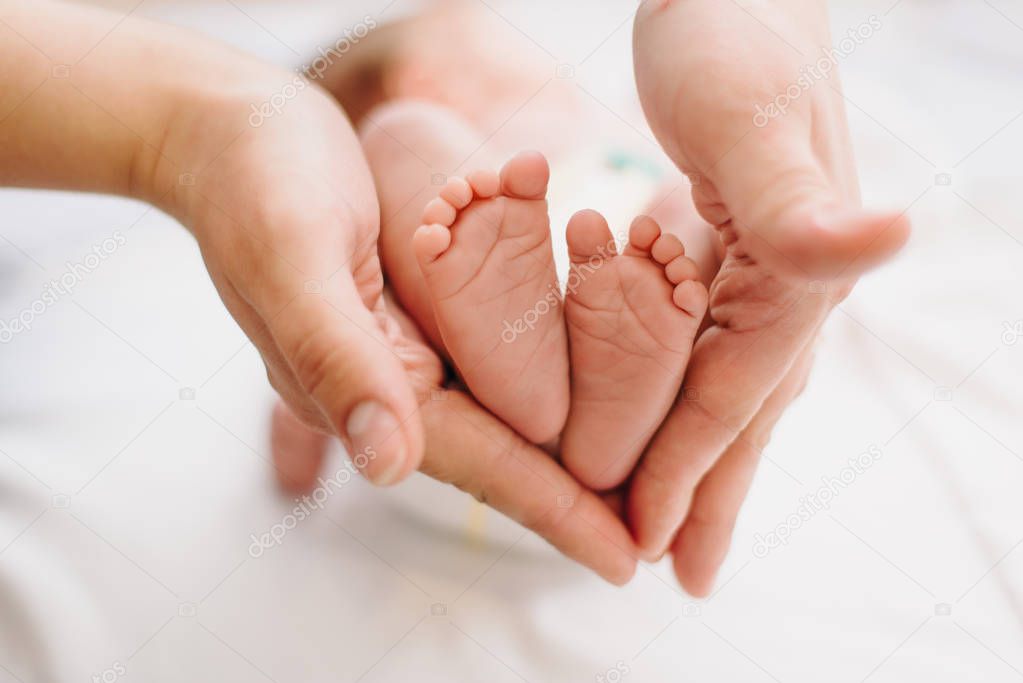 Mother holds baby's feet showing how small they are