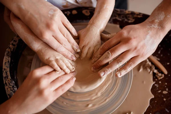 Les mains sculptent de nouveaux ustensiles sur une roue de poterie — Photo