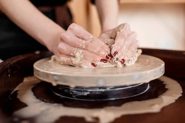 Les mains sculptent de nouveaux ustensiles sur une roue de poterie — Photo