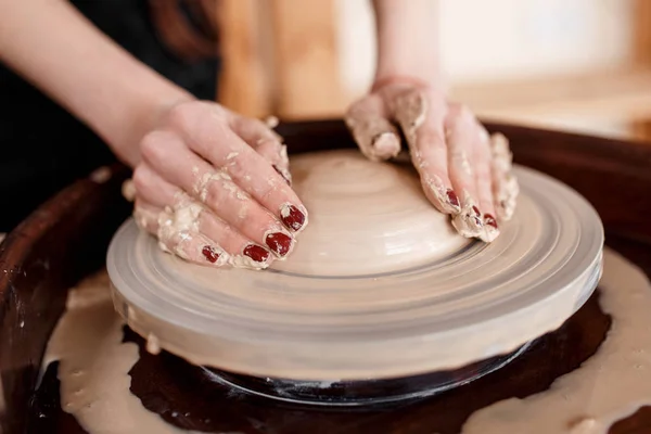 Les mains sculptent de nouveaux ustensiles sur une roue de poterie — Photo