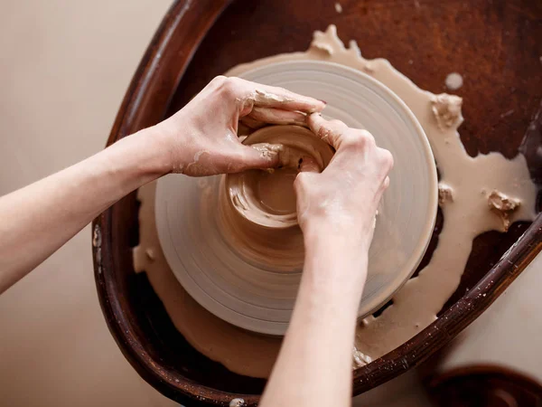 Les mains sculptent de nouveaux ustensiles sur une roue de poterie — Photo