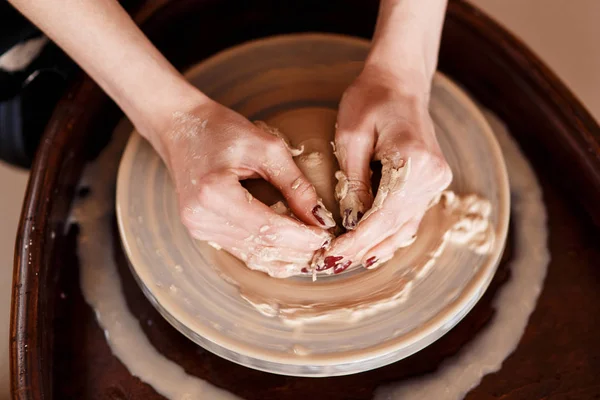 Les mains sculptent de nouveaux ustensiles sur une roue de poterie — Photo