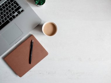 Bilgisayar klavyesi ve diğer ofis malzemeleriyle dolu beyaz ofis masası. Kopyalama alanı olan üst görünüm, düz yatay