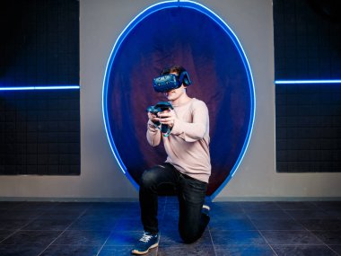 Genç bir adam sanal gerçeklik kask bir oyun odasında video oyunları oynar. oyun kulübü.