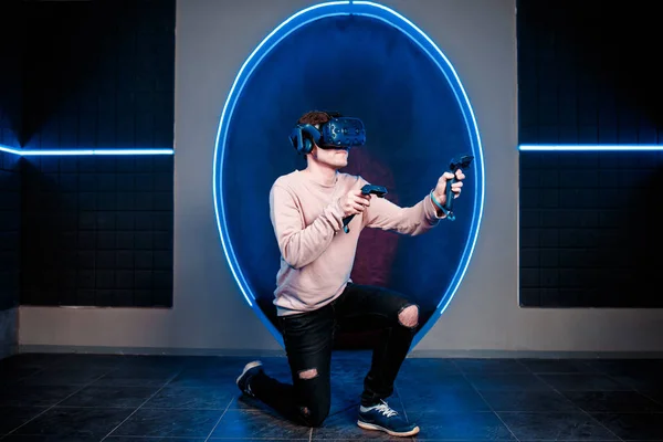 Um jovem joga videogames em uma sala de jogos em um capacete de realidade virtual. clube de jogos . — Fotografia de Stock