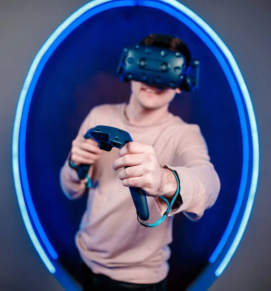 Um jovem joga videogames em uma sala de jogos em um capacete de realidade virtual. clube de jogos . — Fotografia de Stock
