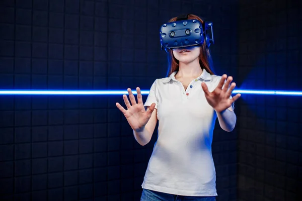 Uma jovem em um capacete de realidade virtual joga em um clube de videogame . — Fotografia de Stock