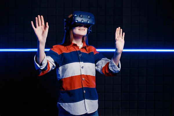 Young girl in a virtual reality helmet in the game room