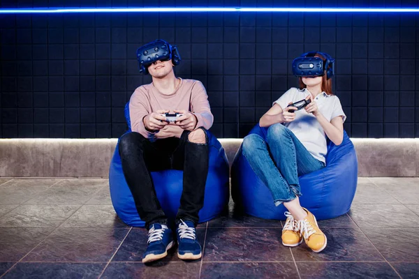 Young guy and girl play in a virtual reality helmet — Stock Photo, Image