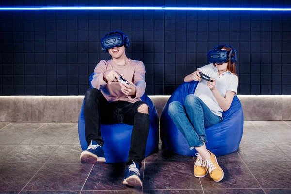 Young guy and girl play in a virtual reality helmet — Stock Photo, Image