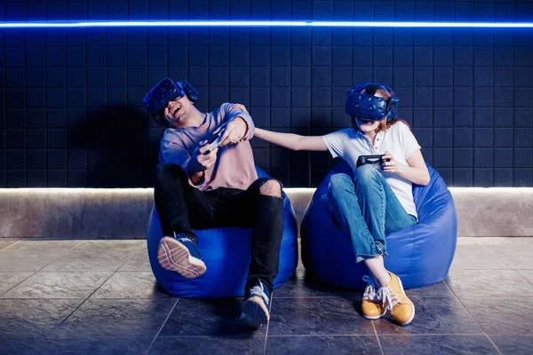 Young guy and girl play in a virtual reality helmet — Stock Photo, Image