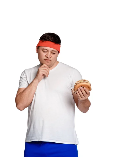 Um homem tem bulimia. Ele está realmente com fome e ele está comendo alimentos pouco saudáveis . — Fotografia de Stock