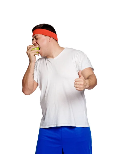 Λίπος άνθρωπος τρώει ένα μήλο που απομονώνονται σε λευκό φόντο — Φωτογραφία Αρχείου