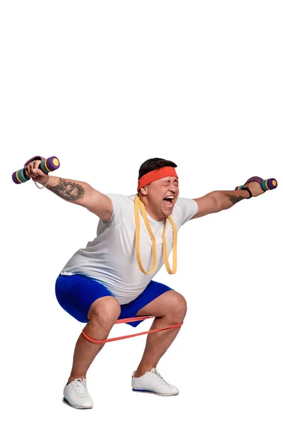Homem gordo exercitando com halteres e olhando para a câmera isolada no branco — Fotografia de Stock