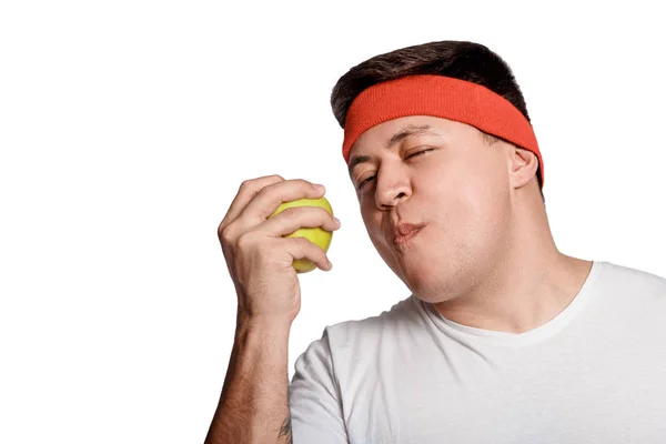 Fett man äter ett äpple isolerad på vit bakgrund — Stockfoto