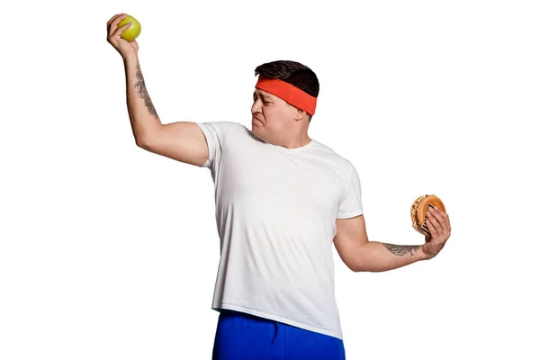 Концептуальна людина робить вибір між здоровою і здоровою їжею. вибір між бургер і яблуком. сила буде при харчуванні . — стокове фото