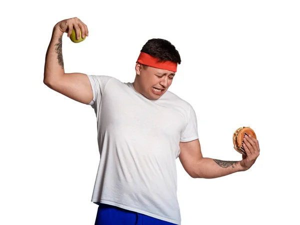 Concept man gör valet mellan hälsosam och ohälsosam mat. valet mellan en hamburgare och ett äpple. kommer att driva när bantning. — Stockfoto