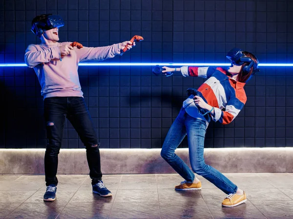 Jovem cara e menina jogar em um capacete realidade virtual — Fotografia de Stock