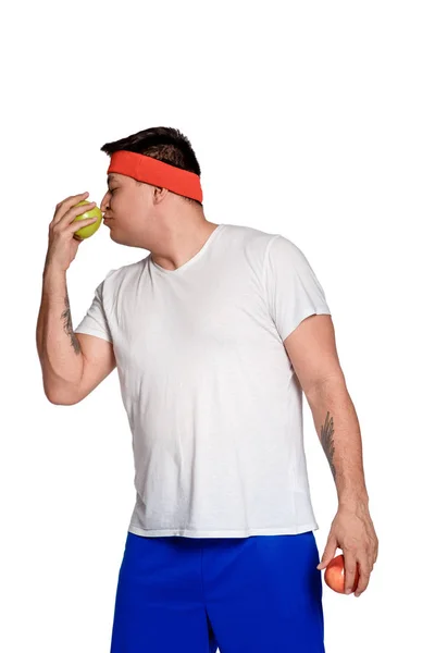 Fet man på en vit bakgrund med ett äpple i hans händer. man valde en hälsosam livsstil. — Stockfoto