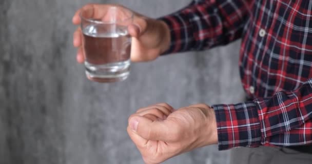 Člověk bere léky. pacient bere prášky se sklenicí vody bez obličeje — Stock video
