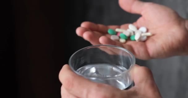 El hombre toma medicamentos. el paciente toma las pastillas con un vaso de agua, sin rostro — Vídeo de stock