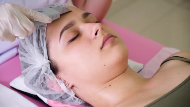 Lo specialista di bellezza rende peeling ultrasonico per il viso femminile dei clienti. Cosmetologo che fa procedura di pulizia del viso con — Video Stock