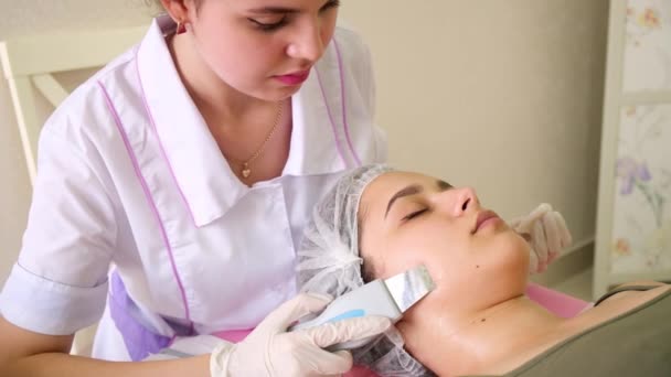 Skönhet Specialist gör Ultrasonic Peeling för kvinnliga kunder ansikte. Kosmetolog gör procedur för rengöring ansikte med — Stockvideo