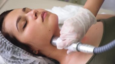 Lenfatik drenaj masajı LPG aygıtı işlemi. Terapist güzellik uzmanı kadın için canlandırıcı bir yüz masajı yapıyor.