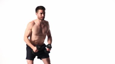 Beyaz arka planda, sakallı, çıplak vücutlu genç yakışıklı adam spor fitness aktivitesi kaldırmakla meşgul.