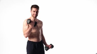 Beyaz arka planda, sakallı, çıplak vücutlu genç yakışıklı adam spor fitness aktivitesi kaldırmakla meşgul.