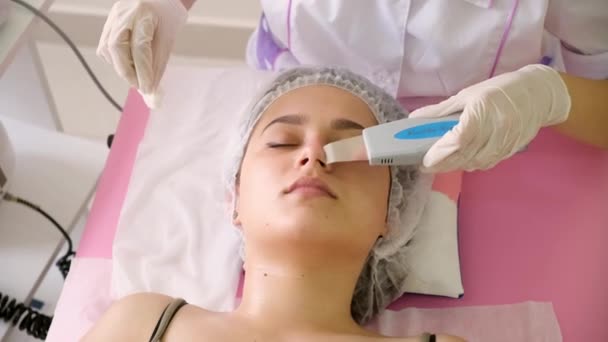 Beauty Specialist sprawia, że Ultradźwiękowy Peeling dla kobiet klientów twarzy. Kosmetolog robi zabieg czyszczenia twarzy z — Wideo stockowe