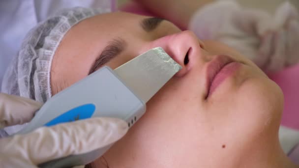 Beauty Specialist sprawia, że Ultradźwiękowy Peeling dla kobiet klientów twarzy. Kosmetolog robi zabieg czyszczenia twarzy z — Wideo stockowe