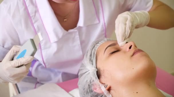 Skönhet Specialist gör Ultrasonic Peeling för kvinnliga kunder ansikte. Kosmetolog gör procedur för rengöring ansikte med — Stockvideo