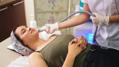 Lenfatik drenaj masajı LPG aygıtı işlemi. Terapist güzellik uzmanı kadın için canlandırıcı bir yüz masajı yapıyor.