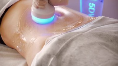 Donanım kozmetolojisi. Vücut bakımı. Spa tedavisi. Ultrason boşluğu, vücut hatları, tedavi. Kadın karşı çıkıyor.