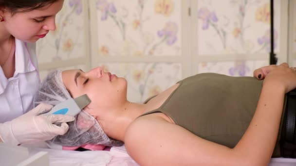 Spesialis Kecantikan Membuat Ultrasonic Mengupas Wajah Klien Perempuan. Kosmetolog melakukan prosedur membersihkan wajah dengan — Stok Video