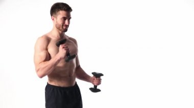 Beyaz arka planda, sakallı, çıplak vücutlu genç yakışıklı adam spor fitness aktivitesi kaldırmakla meşgul.