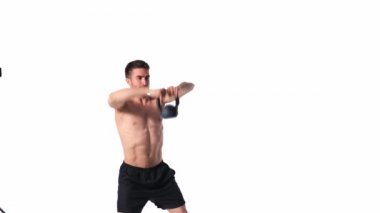 Sakallı, atletik yapılı genç adam beyaz bir arka planda fitness yapıyor. Fitness antrenörü ağırlık kaldırır