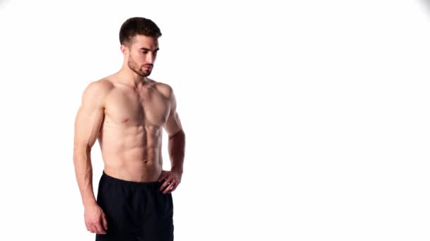 Ein junger Sportmann mit Bart, im Rahmen blickend und lächelnd. Der nackte Oberkörper und die muskulösen Muskeln der Männer. Schöner Kerl — Stockvideo