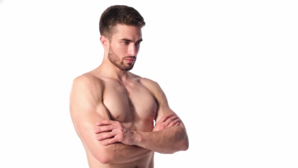 Um jovem desportista com barba, a olhar para a moldura e a sorrir. O tronco nu e músculos musculares dos homens. Bonitão. — Vídeo de Stock