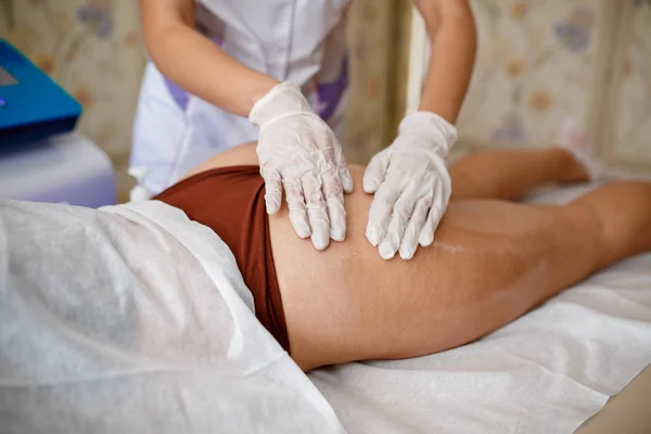 Tratamiento corporal: mujer que se somete a un procedimiento de elevación rf en las nalgas. Forma perfecta nalgas en el tratamiento anti-celulitis. masaje al vacío en las nalgas — Foto de Stock