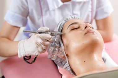 Kozmetik güzellik kliniği. Profesyonel kozmetik uzmanı, Ozon tedavisinde kozmetoloji aparatıyla hücre oksijenlenmesi gerçekleştiriyor. Fizyoterapi. Kaldırma efekti