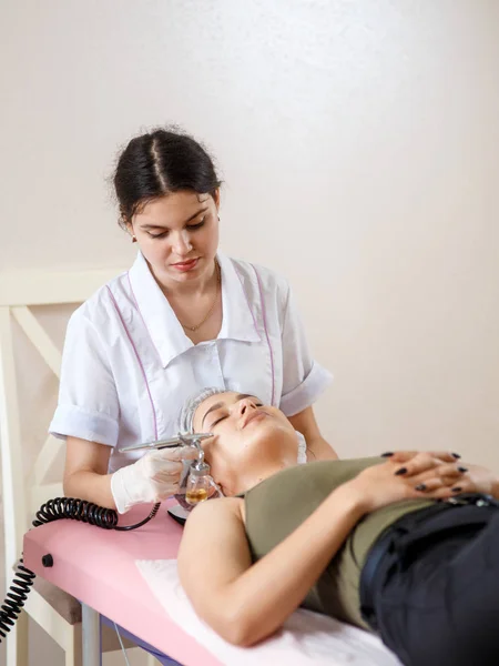 Cosmetología belleza clinic.Professional cosmetólogo lleva a cabo la oxigenación celular para el tratamiento de ozono cara con aparato de cosmetología. Fisioterapía. Efecto de elevación —  Fotos de Stock