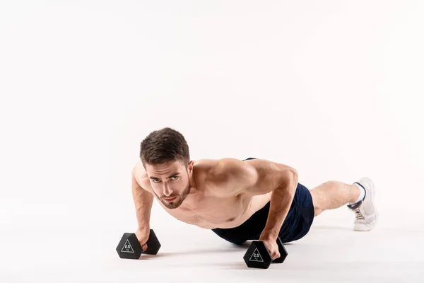 En man med vit isolerad bakgrund knuffar upp på golvet med hantlar. Bearded bodybuilder atletisk — Stockfoto