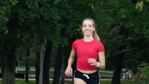 Een jong meisje gaat sporten in de natuur. joggen buiten, cardiotraining in het park — Stockvideo