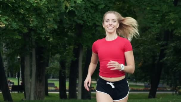 La joven va a practicar deportes en la naturaleza. trotar al aire libre, entrenamiento cardiovascular en el parque — Vídeo de stock