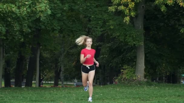 La joven va a practicar deportes en la naturaleza. trotar al aire libre, entrenamiento cardiovascular en el parque — Vídeos de Stock