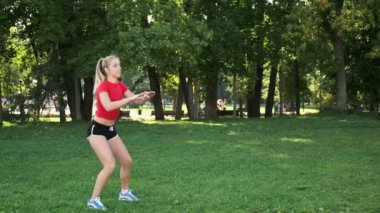 Genç kız doğada eğitim görüyor. Kardiyo çalışması tamam. Parkta yoğun fitness var. Sarışın spora gider.