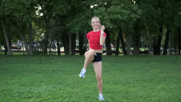 Молода дівчина тренується на природі. кардіо-тренування на місці. Інтенсивна фізична підготовка в парку. блондинка входить для спорту — стокове відео