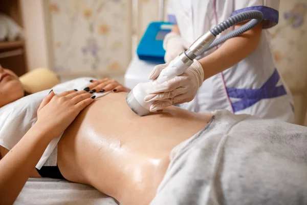 Vakuummassageapparat. Behandling mot celluliter kroppskorrigering. Utrustning för viktminskning. Kvinna och läkare på medicinsalong. Skönhetssalong. vakuummassage av buken. Antikellulitmassage — Stockfoto